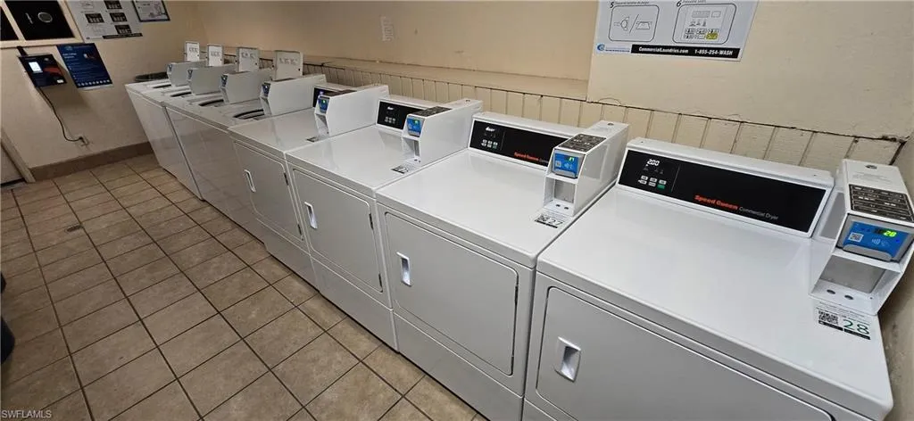 Community laundry room featuring washing machine and clothes dryer