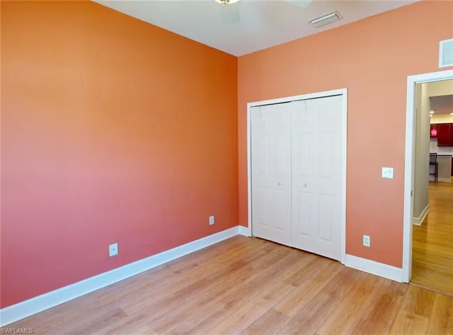 Unfurnished bedroom featuring ceiling fan, a closet, and light wood-type flooring