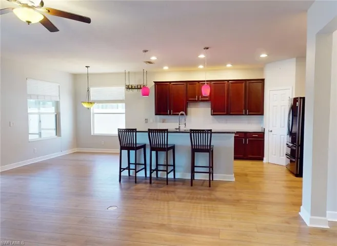 Kitchen featuring ceiling fan, light hardwood / wood-style floors, pendant lighting, sink, and refrigerator