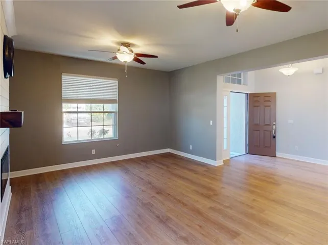 Unfurnished living room featuring ceiling fan and light hardwood / wood-style floors