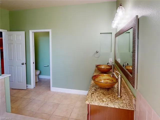 Bathroom featuring tile floors, toilet, and vanity