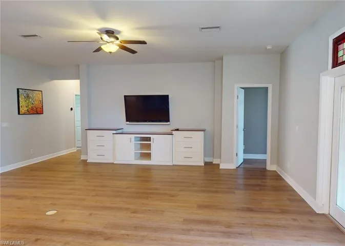 Unfurnished living room with light hardwood / wood-style floors and ceiling fan