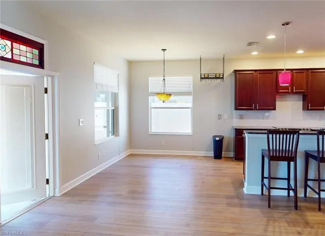 Kitchen with backsplash, light wood-type flooring, and pendant lighting