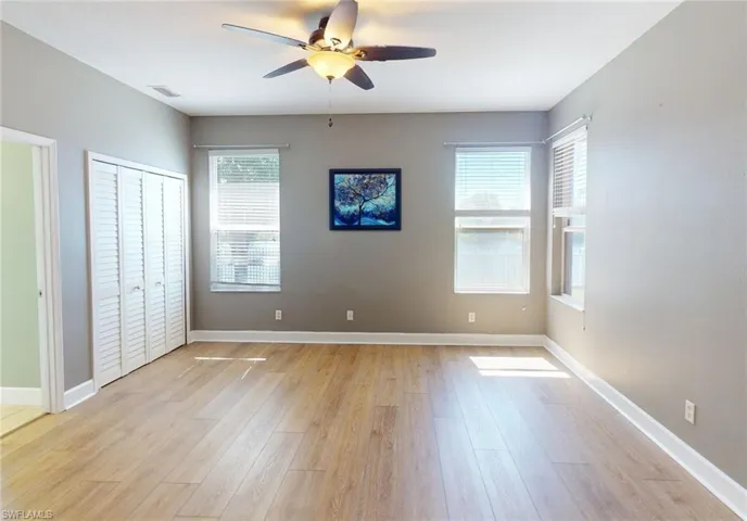 Empty room with ceiling fan and light hardwood / wood-style floors