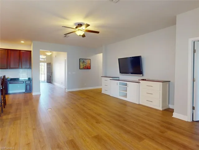 Unfurnished living room featuring ceiling fan and light hardwood / wood-style flooring