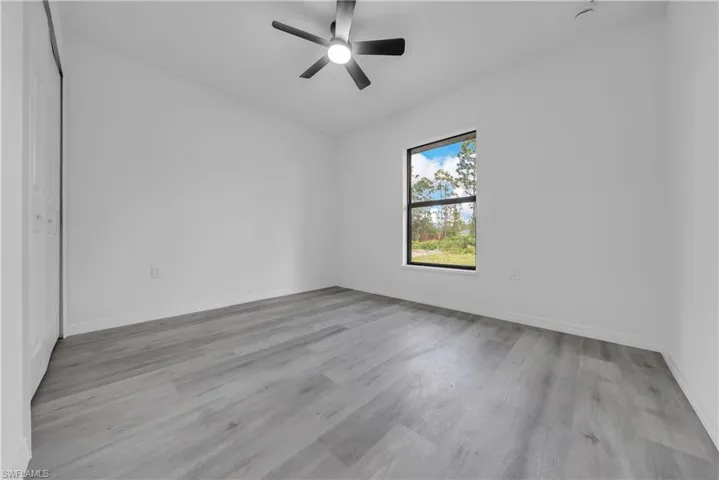 Unfurnished bedroom featuring ceiling fan, light wood finished floors, and a closet