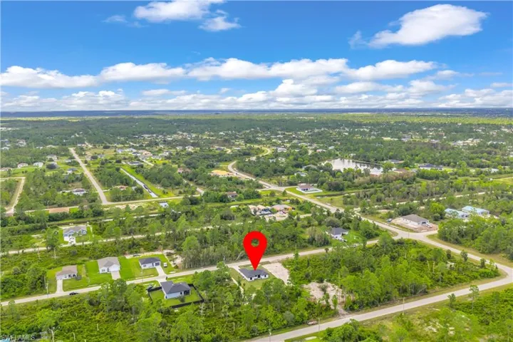 Aerial view of property and surrounding area featuring nearby suburban area and a nearby body of water