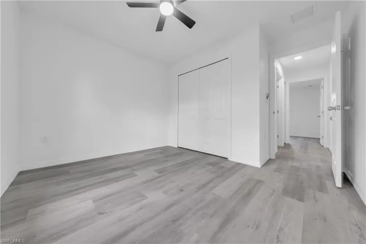 Unfurnished bedroom featuring light wood-style floors, ceiling fan, and a closet