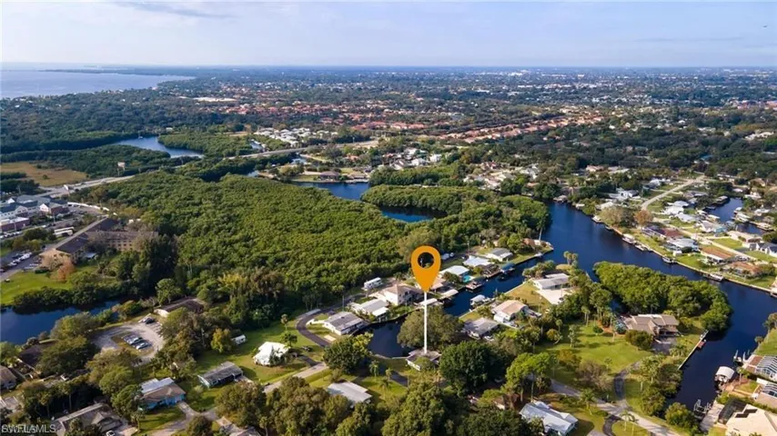 Aerial view of property's location featuring a nearby body of water and nearby suburban area