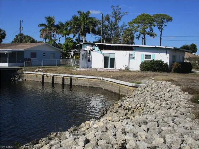 Back of house with stucco siding and a water view
