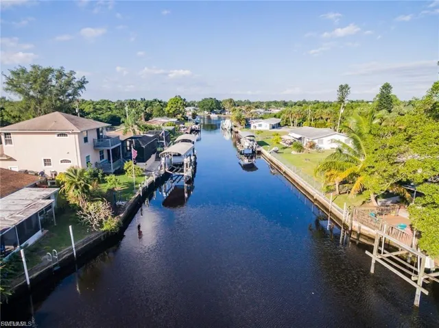 Aerial view of residential area featuring a nearby body of water and a tree filled landscape