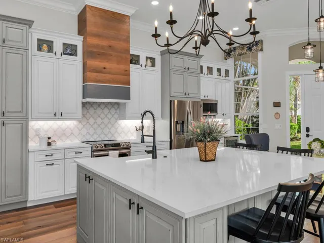 Kitchen with a coffee/wine bar area, an island with sink, crown molding, and stainless steel appliances