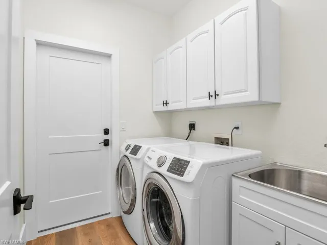 Laundry area with cabinets, laundry tub, separate washer and dryer