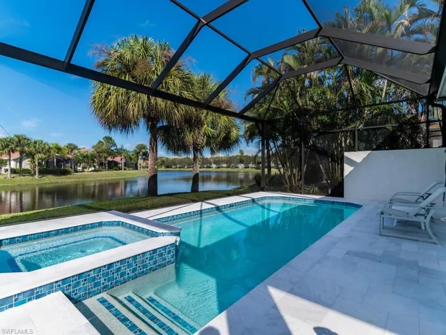 View of pool and long lake and newly designed outdoor space.  Travertine decking, re-surfaced/re-tiled pool, picture framed screen lanai
