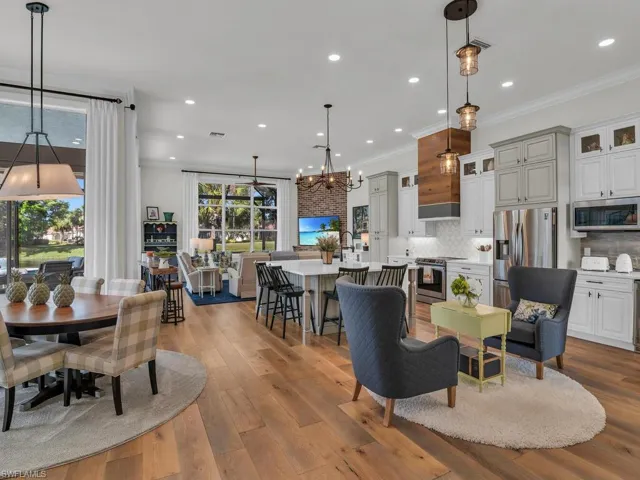 Open living space with light hardwood floors, custom window treatments, motorized blinds, custom kitchen, living area with fireplace, oversized windows with views everywhere.  Light and bright!