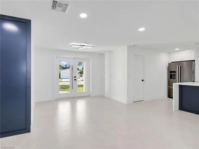 Unfurnished living room featuring recessed lighting and french doors