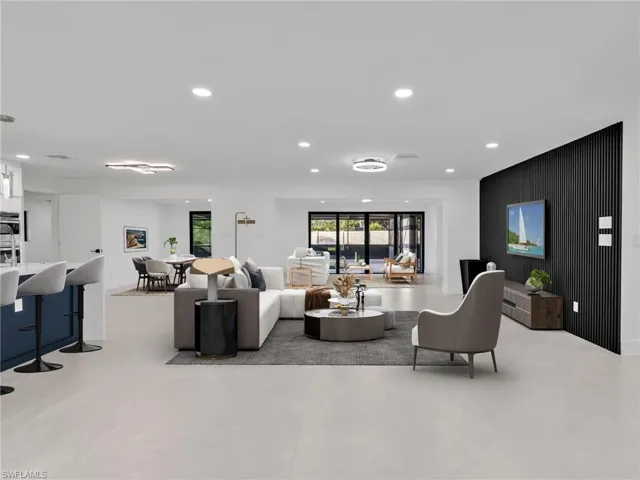 Living room featuring recessed lighting, an accent wall, and wooden walls