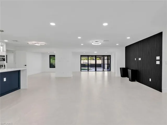 Unfurnished living room featuring recessed lighting and wood walls