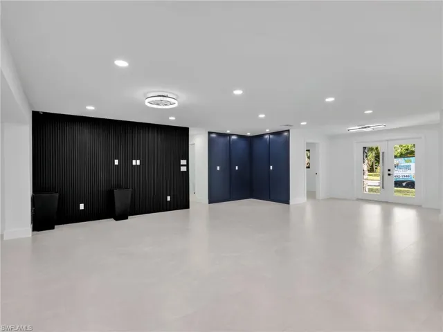 Unfurnished living room featuring french doors and recessed lighting