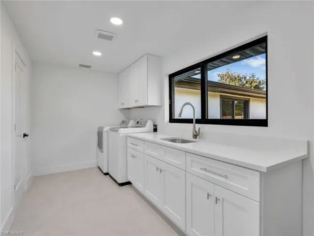 Laundry area featuring recessed lighting, cabinet space, washer and dryer, and light tile patterned floors