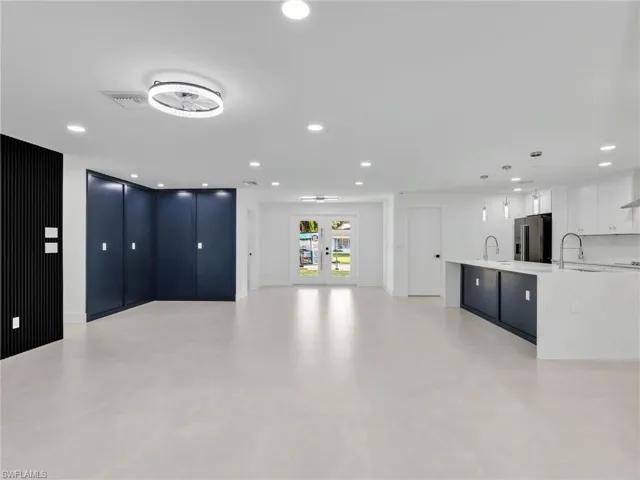 Unfurnished living room with recessed lighting and french doors