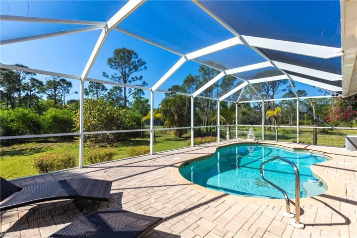 Swimming pool with a patio area and glass enclosure