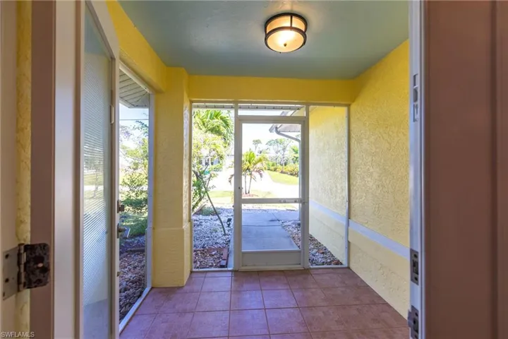 Entryway with a textured wall and tile patterned floors