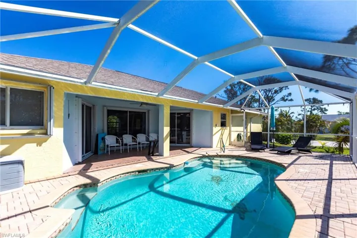 Outdoor pool featuring a patio area, glass enclosure, and a ceiling fan