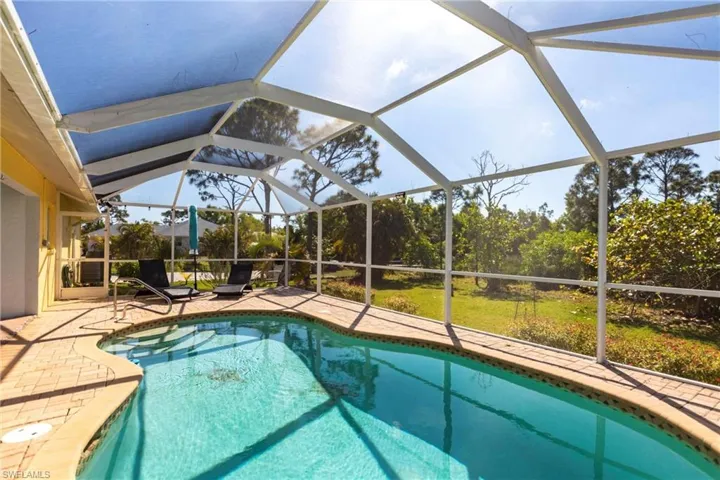 Outdoor pool featuring a patio and glass enclosure