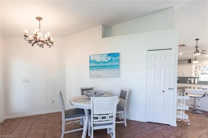 Dining area featuring a chandelier, light tile patterned flooring, lofted ceiling, and recessed lighting