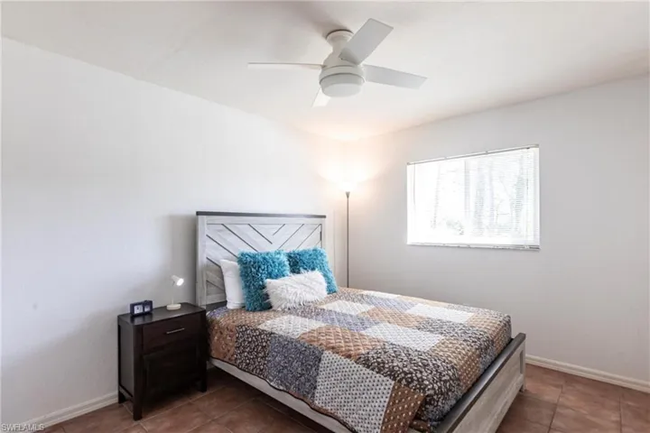Tiled bedroom with baseboards and a ceiling fan