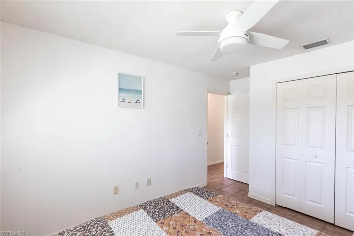 Unfurnished bedroom with tile patterned flooring, a closet, and ceiling fan