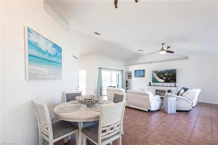 Dining area featuring a ceiling fan, lofted ceiling, and tile patterned floors