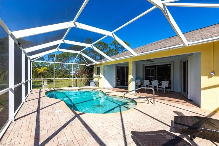 Swimming pool featuring a patio, a ceiling fan, and a lanai