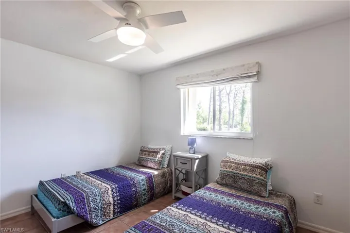 Tiled bedroom featuring ceiling fan
