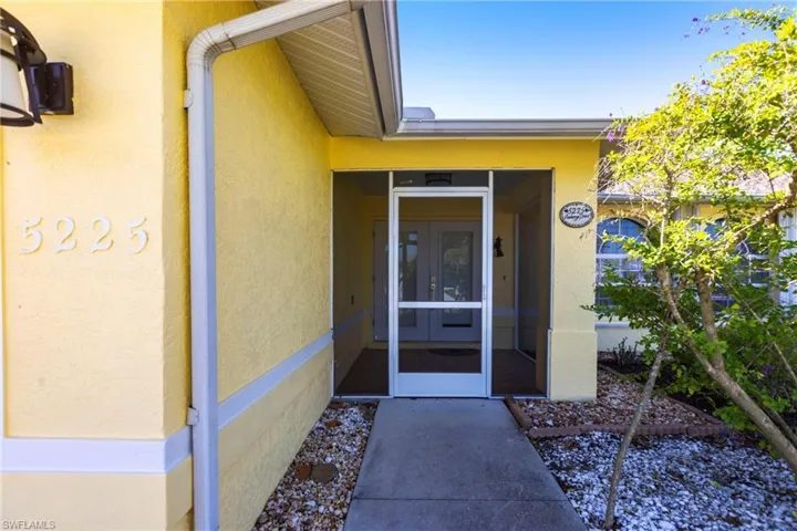 Doorway to property featuring stucco siding and french doors