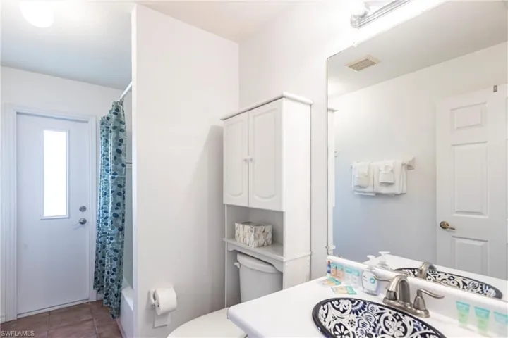 Bathroom with vanity, tile patterned floors, and shower / bathtub combination with curtain