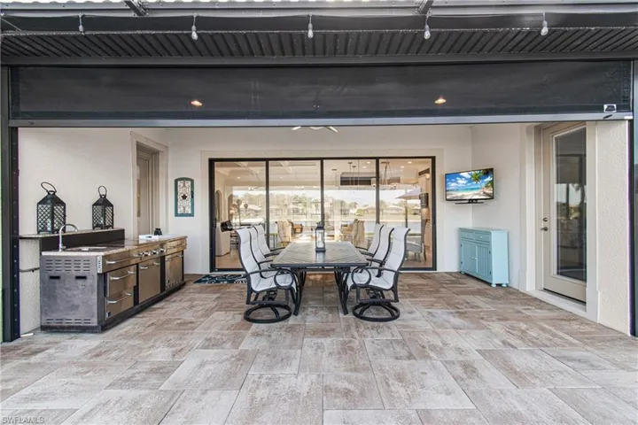 AMAZING VIEW INSIDE OF LANAI INTO HOME WITH STORM SMART ELECTRIC SCREENS, AN OUTDOOR KITCHEN PLUS ENTRY DOOR TO THE MASTER ON RIGHT, ENTRY TO GUEST BATHROOM TO THE LEFT & 4 SLIDING STACKABLE GLASS DOORS PERFECT FOR ENTERTAINING!