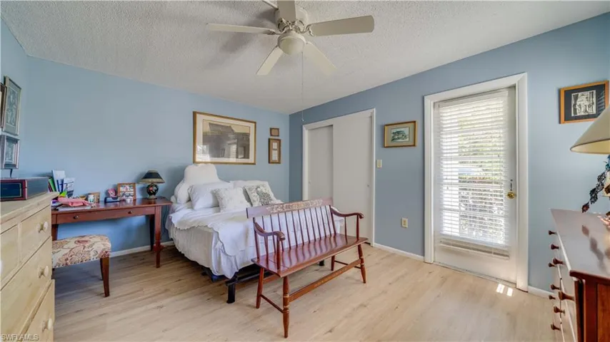 Bedroom with baseboards, a textured ceiling, ceiling fan, and light wood finished floors
