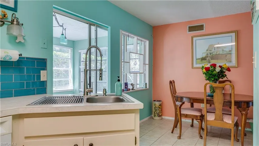 Kitchen with visible vents, backsplash, baseboards, light countertops, and light tile patterned floors