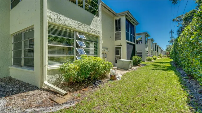 View of side of property with a yard and stucco siding