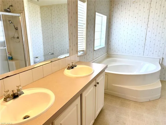 Full bathroom with plus walk in shower, vanity, and toilet