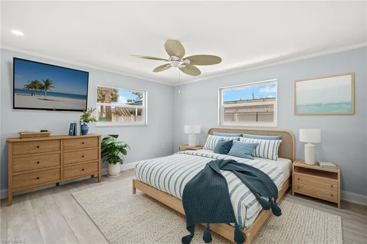 Virtual Imaging Primary Bedroom with baseboards, crown molding, multiple windows, light wood-style ceramic floors, and ceiling fan
