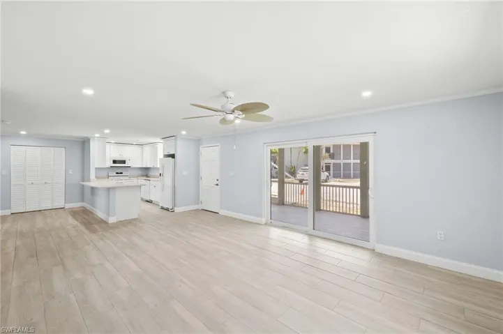 Living room with baseboards, a ceiling fan, light wood-style ceramic floors, recessed lighting, and crown molding