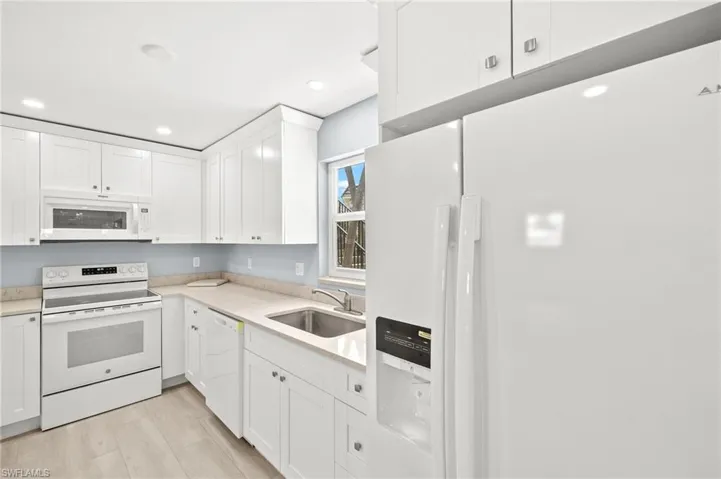 Kitchen featuring New white appliances, a sink, white cabinetry, light quartz countertops, and recessed lighting