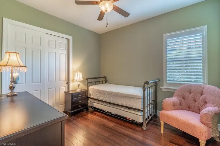 Bedroom with a closet, ceiling fan, and dark hardwood / wood-style flooring