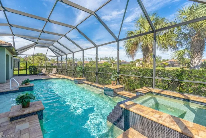 View of pool with an in ground hot tub, a patio, and a lanai