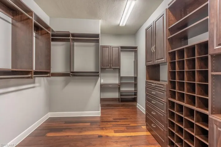 Spacious closet featuring dark hardwood / wood-style floors
