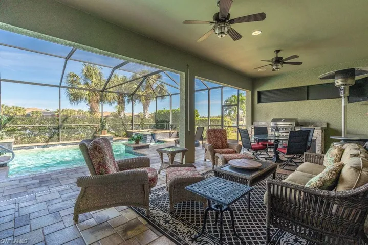 Sunroom / solarium with ceiling fan and a pool