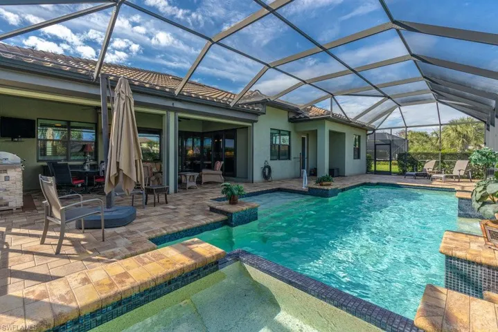 View of pool featuring a lanai, ceiling fan, and a patio area